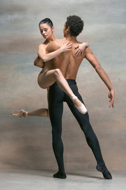 Couple of ballet dancers posing over gray background - Foto, Bild