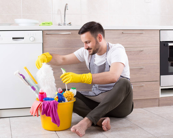 Άνθρωπος με καθαρίζοντας προμήθειες στην κουζίνα - Φωτογραφία, εικόνα