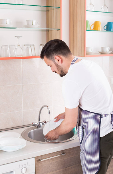 Man washing dishes - Фото, изображение