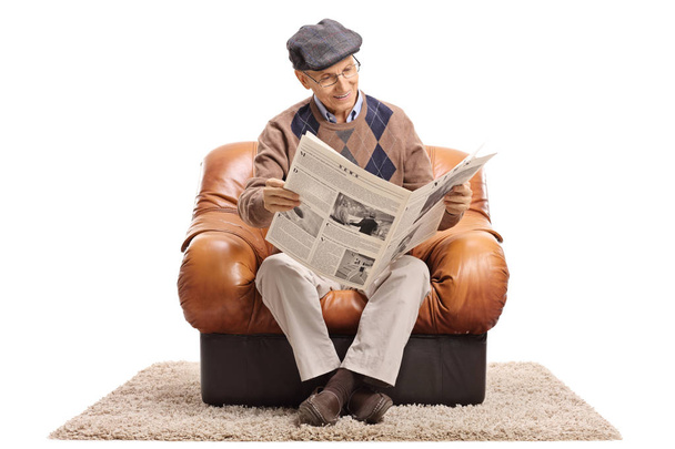 bir koltukta oturan ve bir gazete okuyan adam - Fotoğraf, Görsel
