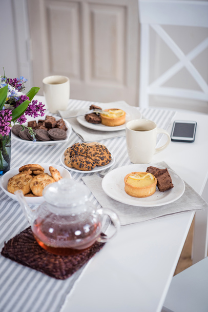 tea and various pastry on tabletop - Fotó, kép