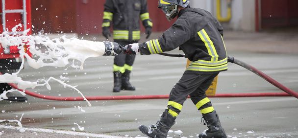 Firefighters while extinguishing the fire with foam - Фото, зображення