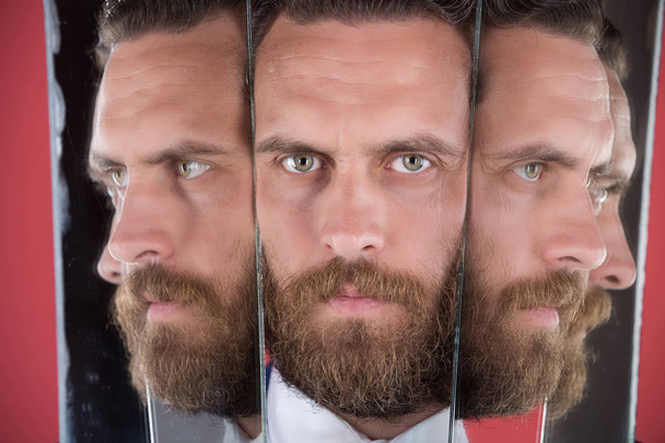 face of serious bearded hipster man, businessman reflecting in mirror - Фото, изображение