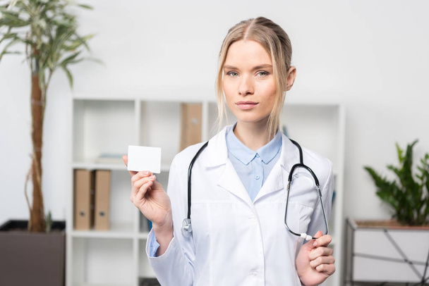 Doctor holding business card  - Photo, image