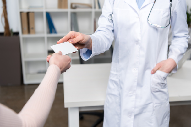 Médico dando tarjeta al paciente
  - Foto, Imagen