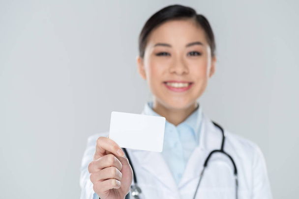 Doctor sosteniendo tarjeta en blanco
 - Foto, Imagen
