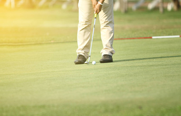 Азиатские гольфисты хит подметать и держать поле для гольфа в летнее время
 - Фото, изображение