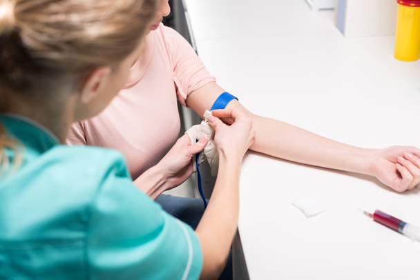 Krankenschwester bereitet Patientin auf Blutanalyse vor - Foto, Bild