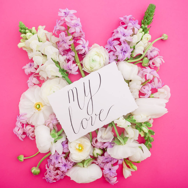 Floral composition with different kind of flowers and card with lettering My Love on pink background - Photo, Image