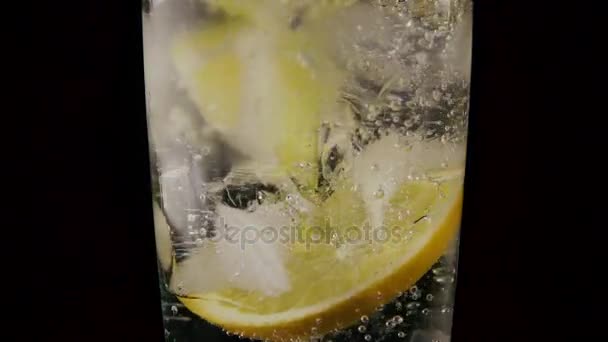In a glass with soda ice and lemon drop the straw. Slow motion - Footage, Video