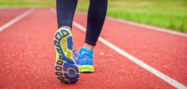 Athletic woman feet on running track close up on shoe - Photo, Image