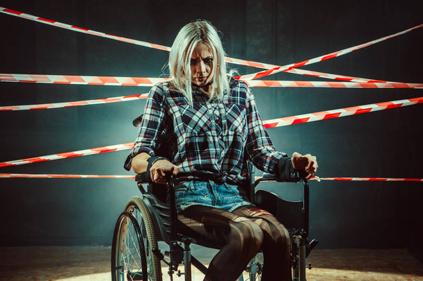 Красива жінка в інвалідному візку на темному тлі
. - Фото, зображення