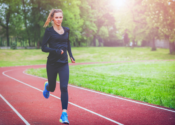Athletic woman running on track, healthy lifestyle - Photo, image