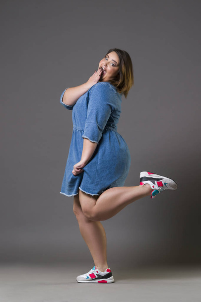 Plus size fashion model in casual clothes, fat woman on gray background, overweight female body - Fotó, kép