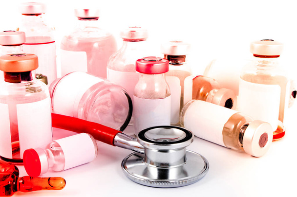Ampollas médicas pastillas, jeringa y estetoscopio médico en laboratorio
. - Foto, Imagen