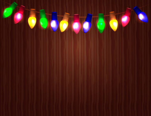 String of Color christmas light bulbs  on wooden background. - Wektor, obraz