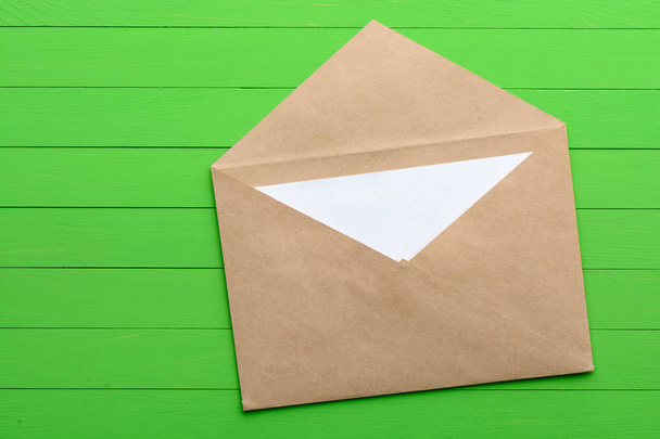 Порожній аркуш паперу з конвертом на зеленому дерев'яному фоні
 - Фото, зображення