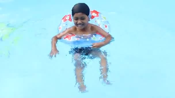 Ładny, mały chłopiec, pływanie w basenie - Materiał filmowy, wideo