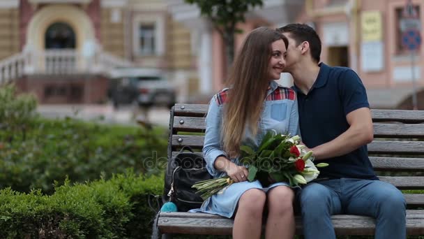 Atractiva pareja de citas sentado en el banco en el parque
 - Metraje, vídeo