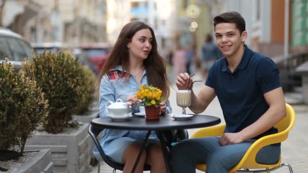 Aantrekkelijke paar ontspannen in sidewalk café - Video