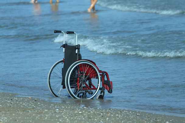 Інвалідне крісло на березі моря в спекотний сонячний літній день
 - Фото, зображення