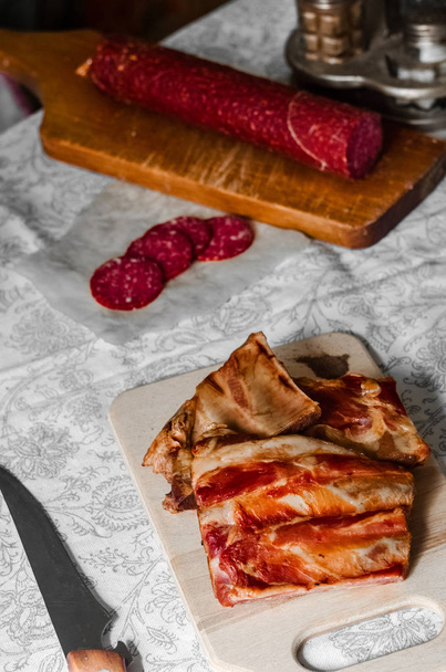 Smoked ribs and chopped pieces of salami - Foto, afbeelding