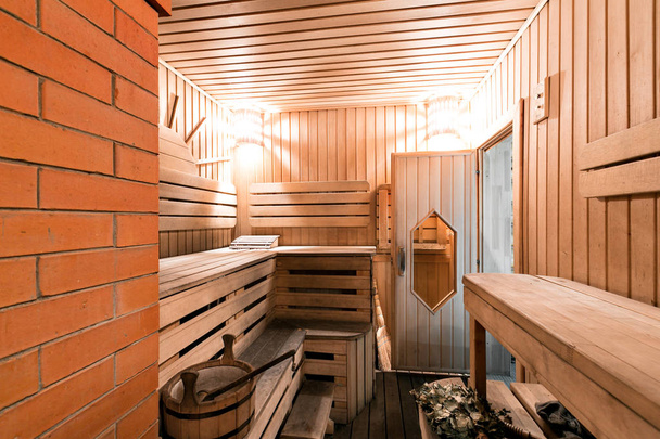 Houten sauna ruimte met pollepel leeg, emmer klaar om te worden gebruikt - Foto, afbeelding
