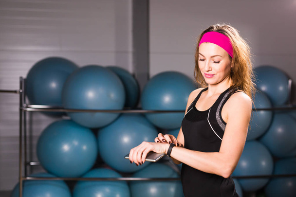 Woman using activity tracker or heart rate monitor. Indoors fitness concept - 写真・画像