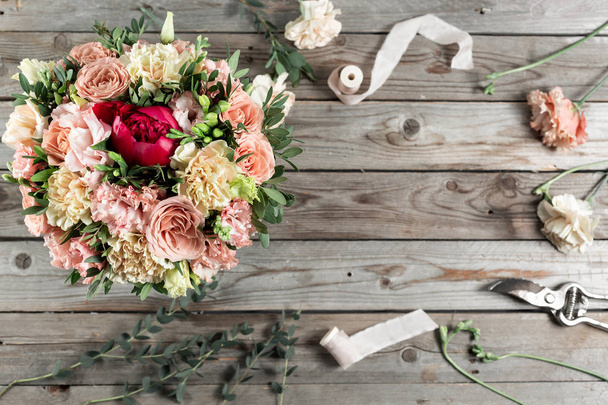 The florist desktop with working tools on gray old wooden background - Foto, afbeelding