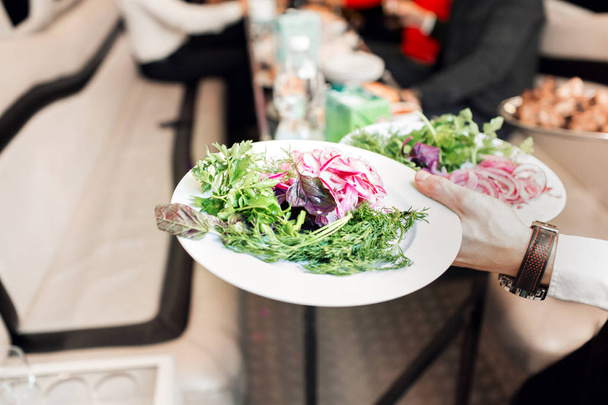 Gemüse und Salat hautnah. Kellnerin bringt Essen an den Tisch - Foto, Bild