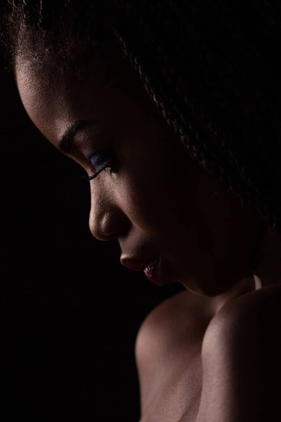 Close up portrait of dark skinned model on black backstage. - 写真・画像
