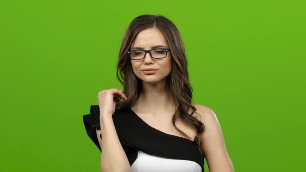 Brunette with glasses starts flirting, she smiles sweetly. Green screen - Кадры, видео