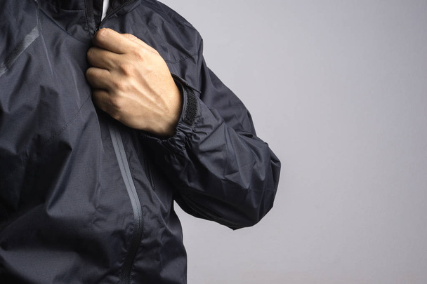 Homem vestindo jaqueta anti-estática ou molhada preta ou capa de chuva
 - Foto, Imagem