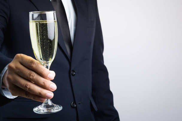 ビジネスマンの手のお祝いのためのシャンパンのグラス - 写真・画像