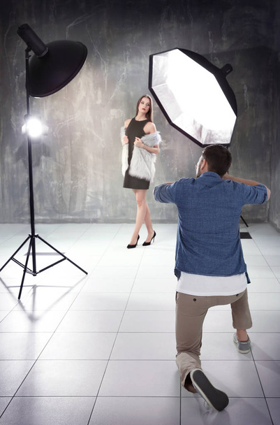 Young beautiful model posing for professional photographer in studio - Фото, изображение