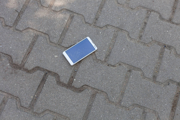 Téléphone avec écran cassé sur le trottoir
 - Photo, image