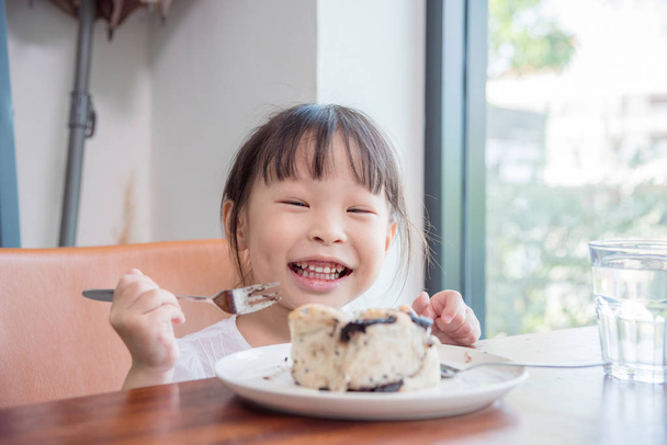 menina comer pão com chocolate em casa
 - Foto, Imagem