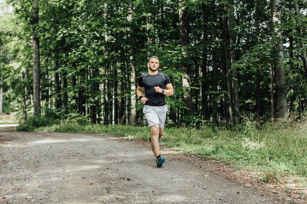 Mężczyzna biegacz dydaktyczna po lesie - Zdjęcie, obraz