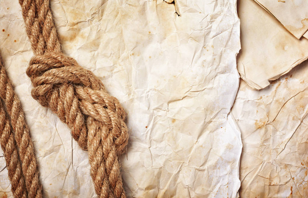 Close-up view of a sea knot of rope on retro paper - Фото, изображение