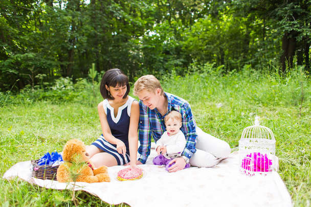щасливі змішаної раси сім'ї з пікніка і граючи в парку - Фото, зображення