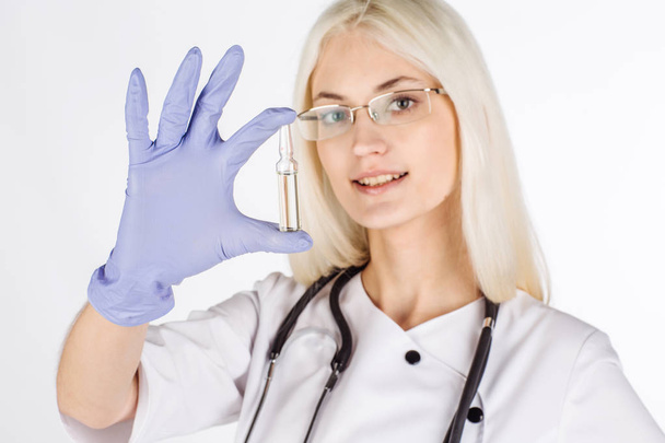 Doctor with hand in medical glove holding ampoulem - Foto, Bild