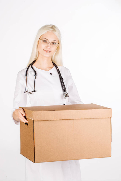 doctor smiling, holding box and looking at camera - Photo, image