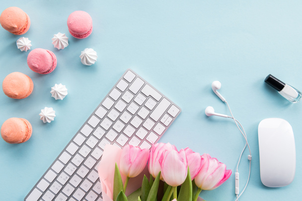 toetsenbord, macarons en bloemen op tafelblad - Foto, afbeelding