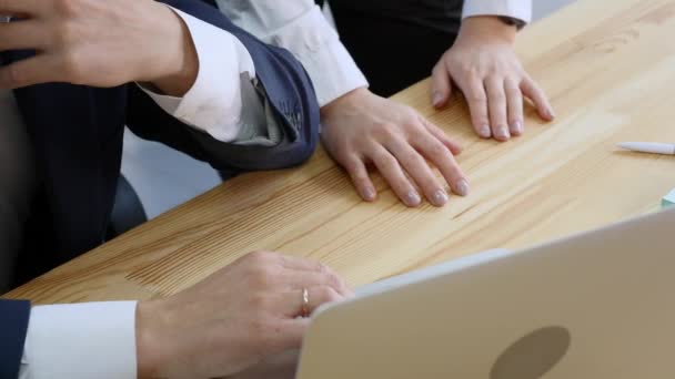 A menina bonita consulta com homens sobre o projeto no computador portátil no escritório. Ele mostra um dedo na tela que você precisa corrigir. O conceito de trabalho em equipe no co-trabalho
 - Filmagem, Vídeo