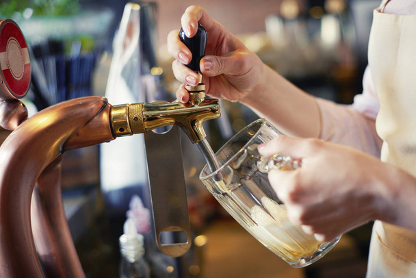 Close up de bartender derramando copo de cerveja
  - Foto, Imagem