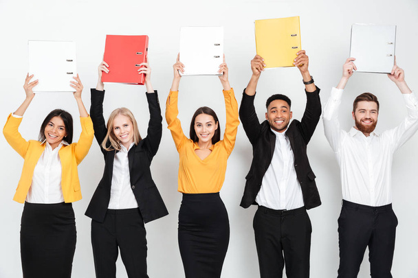 Happy colleagues standing isolated with folders in office - Foto, Imagem