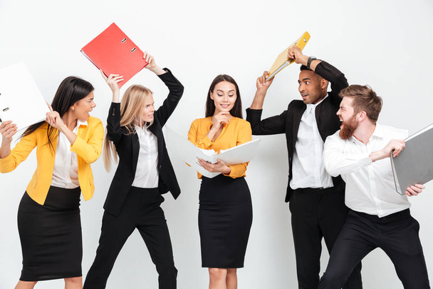 Happy woman holding folder while angry colleagues fighting - Foto, Imagem