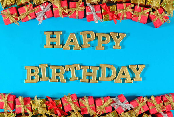 Alles Gute zum Geburtstag goldener Text und goldene und rote Geschenke auf blauem Grund - Foto, Bild
