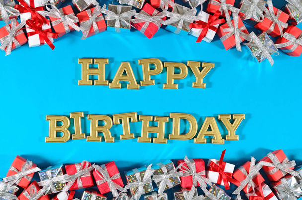 Joyeux anniversaire texte doré et cadeaux argent et rouge sur un bleu
 - Photo, image