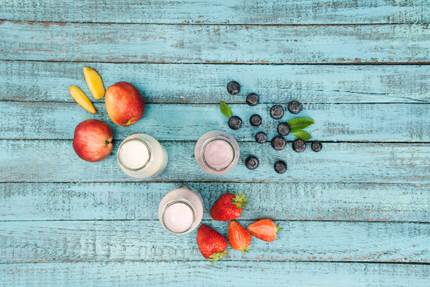 koktajle mleczne w szklanych butelkach z jagodami i owocami - Zdjęcie, obraz